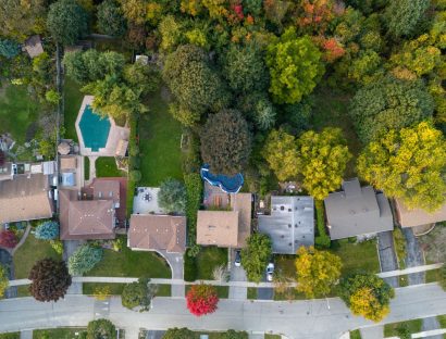 Aerial view of a tree-lined neighborhood with backyard pools, for St. Rose homeowners